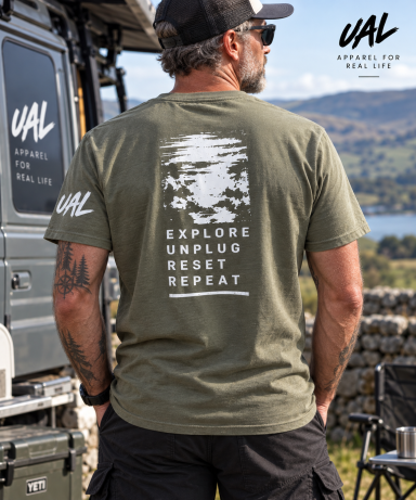 UAL Explore Unplug Reset Repeat T-Shirt Man wearing an olive green UAL Explore Unplug Reset Repeat back print T-shirt