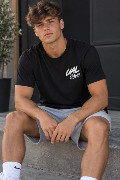 UAL Calm T-Shirt – Black Young man wearing black UAL Calm T-shirt with small white chest logo